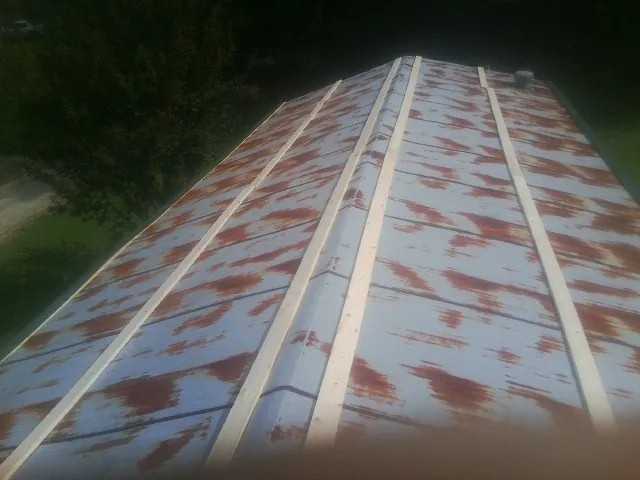 Rusted metal roof panels with new wood purlins before replacement — Storm Damage Roof Repair in Prague by Roofing Brothers